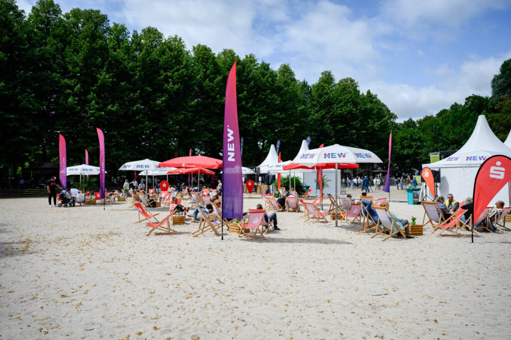 Sitzbereich mit Liegestühlen und Sonnenschirmen beim Fest am See 2026 im Schlosspark Wickrath.