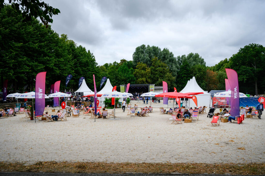 Blick über das Fest am See 2026 mit Sitzgelegenheiten, Marktständen und Bühne im Schlosspark Wickrath