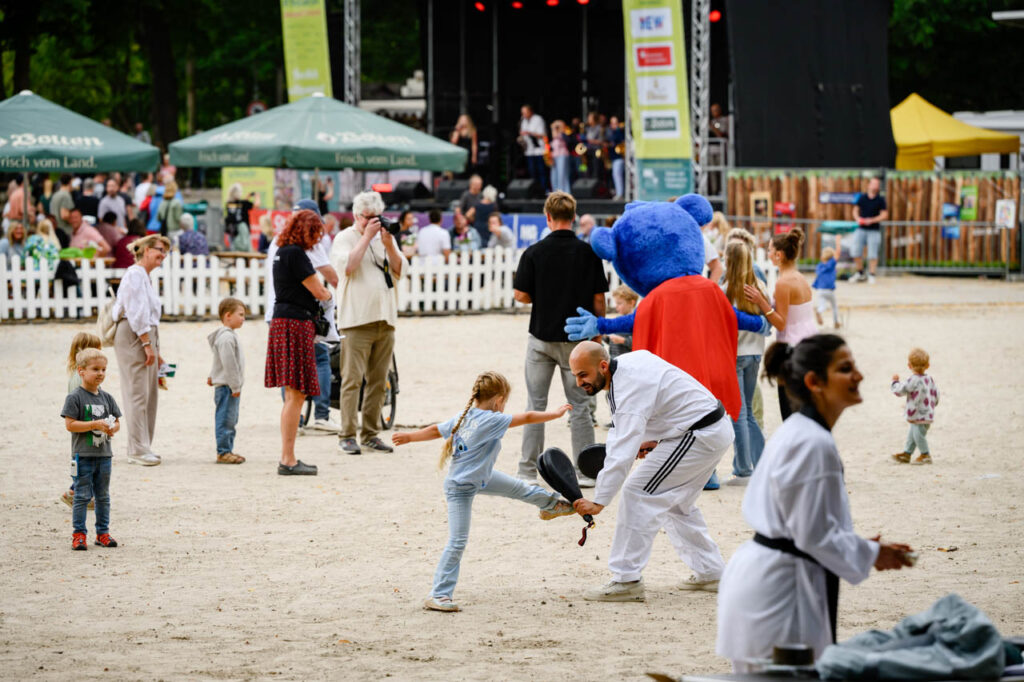 Kind probiert gemeinsam mit einem Erwachsenen eine Kampfsportübung beim Fest am See 2026 aus.