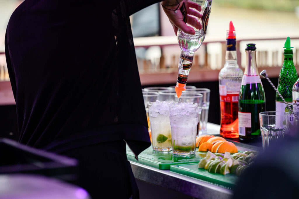 Cocktails mit Eis, Limetten und Orangen werden an einer Bar beim Fest am See 2026 zubereitet.