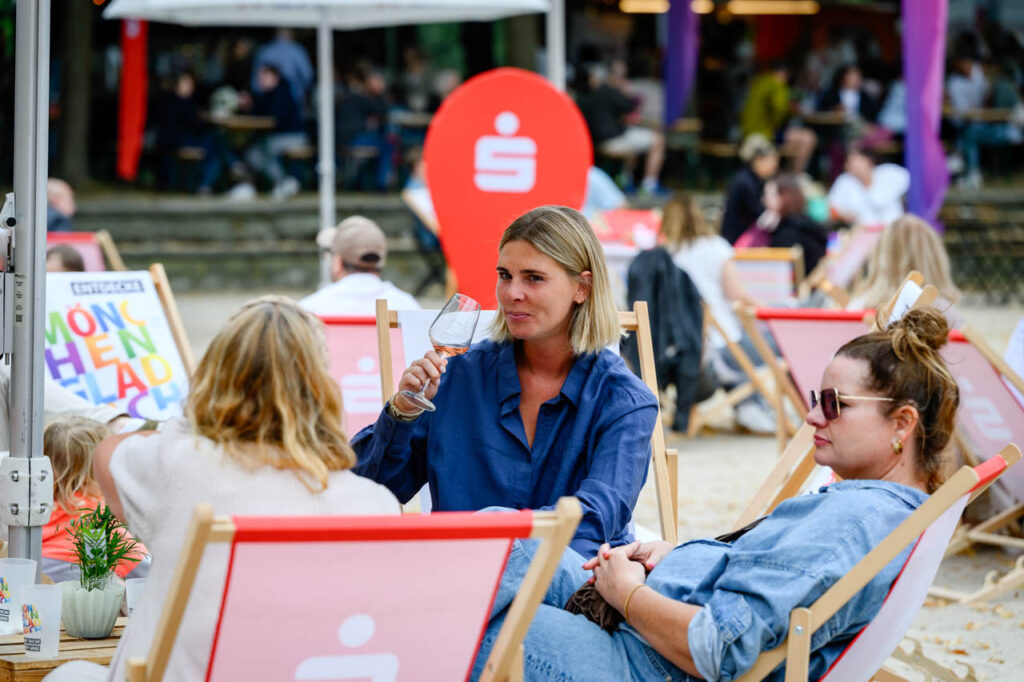Besucherinnen sitzen mit Getränken in Liegestühlen im Beachbereich beim Fest am See 2026.
