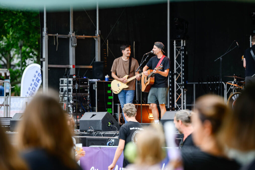 Band spielt mit Gitarren auf der Bühne beim Fest am See 2026 im Schlosspark Wickrath.