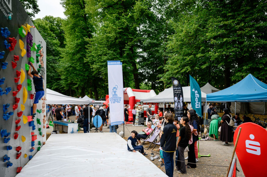 Ein Kind klettert an einer bunten Kletterwand beim Fest am See 2026 im Schlosspark Wickrath.