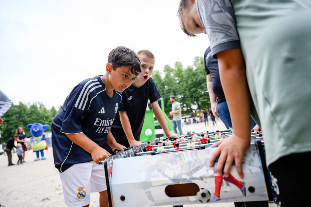 Kinder spielen gemeinsam Tischkicker beim Fest am See 2026 im Schlosspark Wickrath.